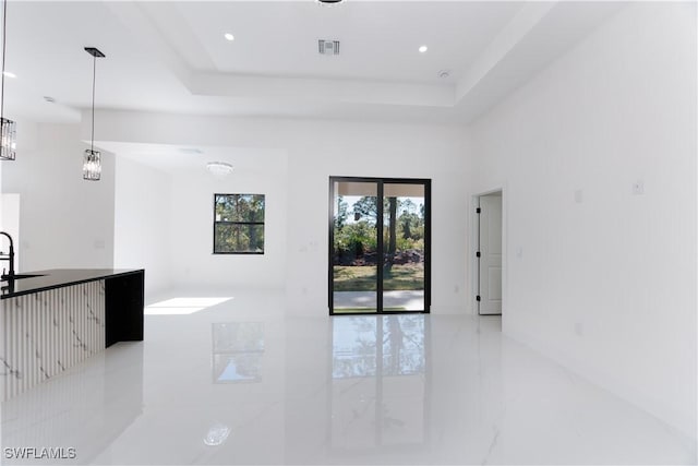 interior space with a raised ceiling and sink