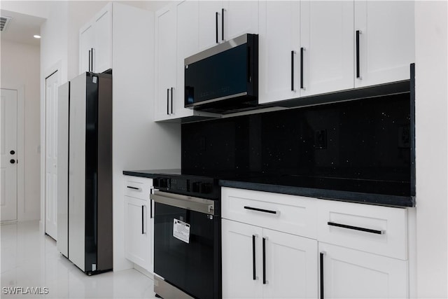 kitchen featuring backsplash, stainless steel appliances, and white cabinetry