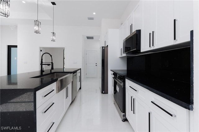 kitchen with stainless steel appliances, white cabinetry, a center island with sink, and sink