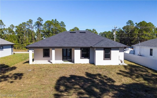 back of property with a patio and a lawn