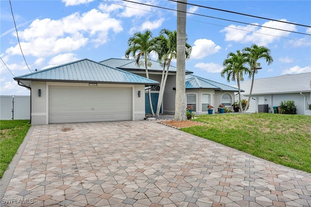 view of front of house with central AC unit, a front yard, and a garage