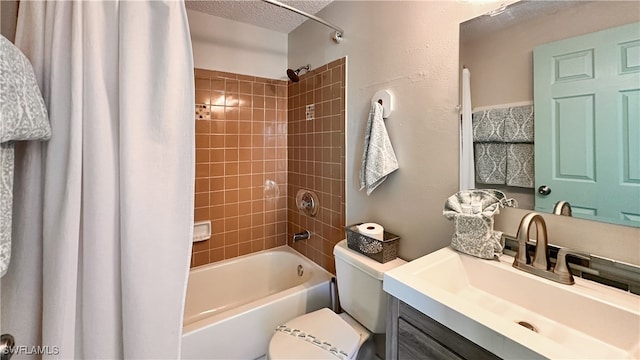 full bathroom featuring vanity, toilet, shower / bath combo with shower curtain, and a textured ceiling