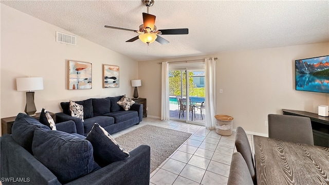 living room with light tile patterned floors, a textured ceiling, ceiling fan, and lofted ceiling