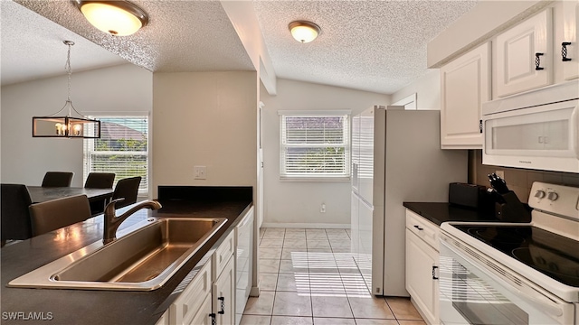 kitchen with white appliances, white cabinets, sink, hanging light fixtures, and vaulted ceiling with beams