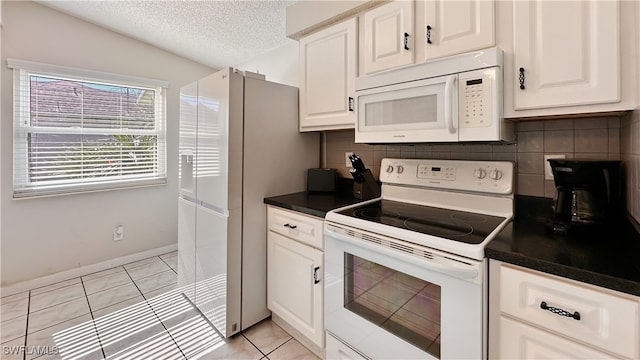 kitchen with backsplash, lofted ceiling, a textured ceiling, white appliances, and light tile patterned flooring