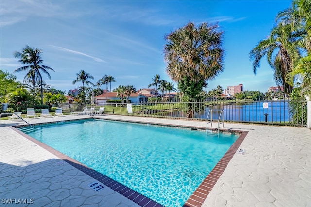 view of pool with a patio and a water view