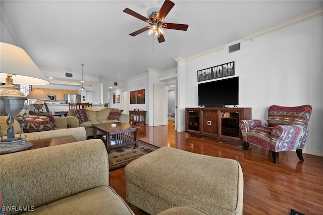 living room featuring hardwood / wood-style flooring, ornamental molding, and ceiling fan