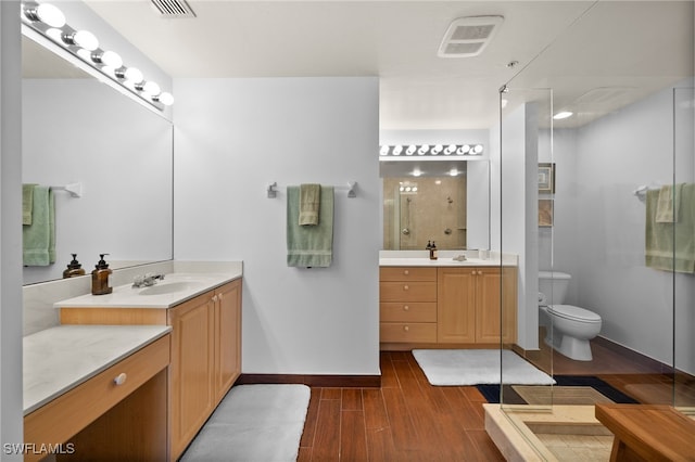 bathroom with vanity, wood-type flooring, a shower with door, and toilet