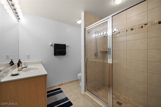 bathroom with vanity, a shower with door, tile patterned floors, and toilet