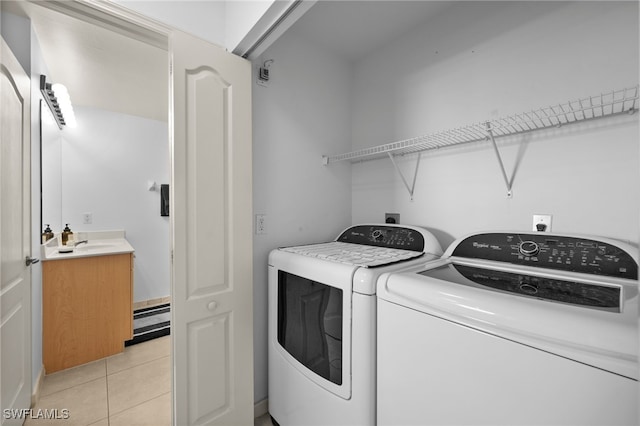 laundry room featuring baseboard heating, independent washer and dryer, sink, and light tile patterned floors