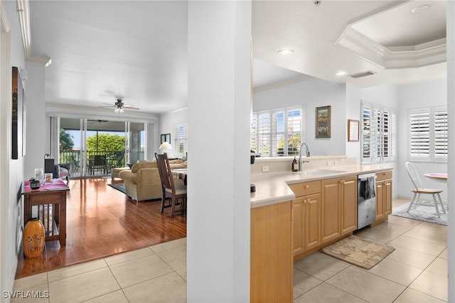 kitchen with light tile patterned floors, ornamental molding, dishwasher, and light brown cabinets