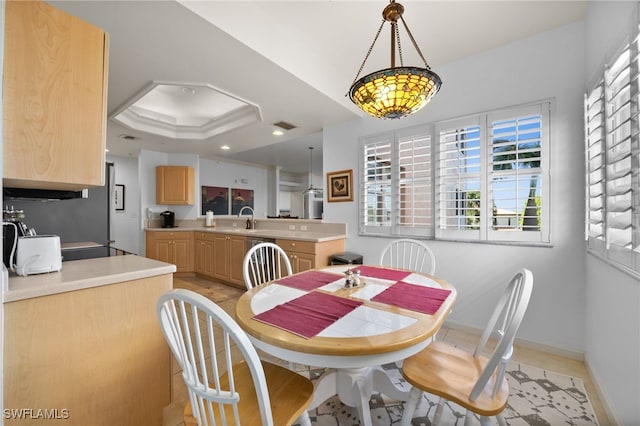 dining room featuring a raised ceiling and sink