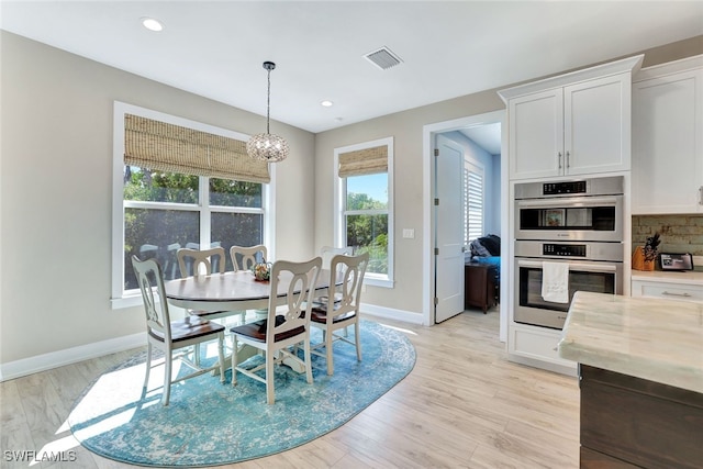 dining area with a chandelier and light hardwood / wood-style floors