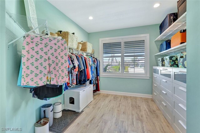 walk in closet with light hardwood / wood-style floors