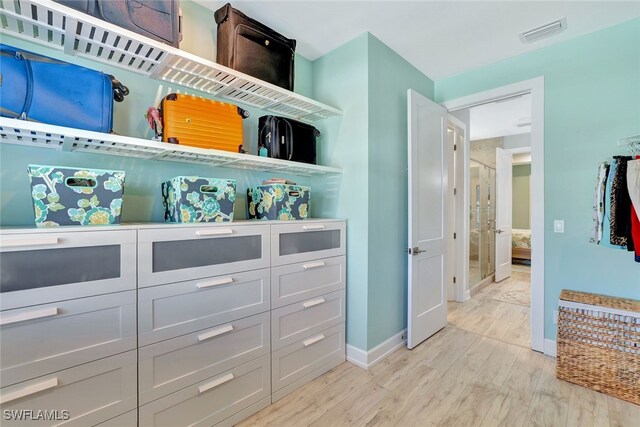 spacious closet featuring light hardwood / wood-style floors