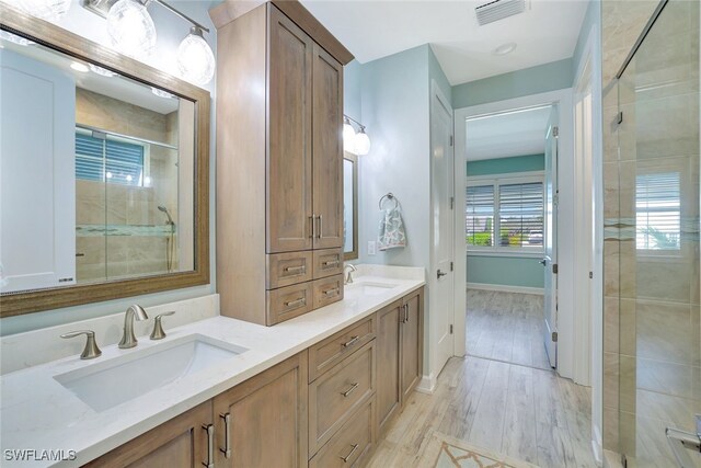 bathroom featuring vanity, hardwood / wood-style flooring, and a shower with shower door