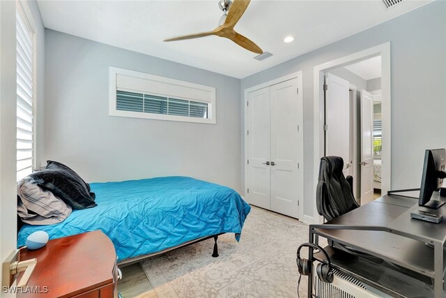 bedroom featuring multiple windows, a closet, and ceiling fan