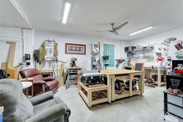 living room featuring concrete flooring, a workshop area, and ceiling fan