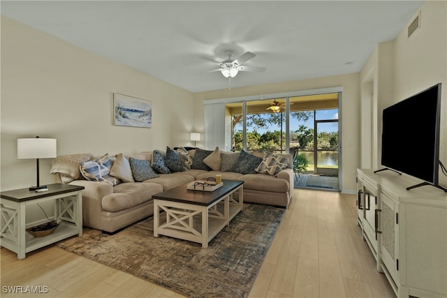 living room with ceiling fan and light hardwood / wood-style flooring