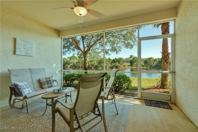 sunroom / solarium with a water view and ceiling fan