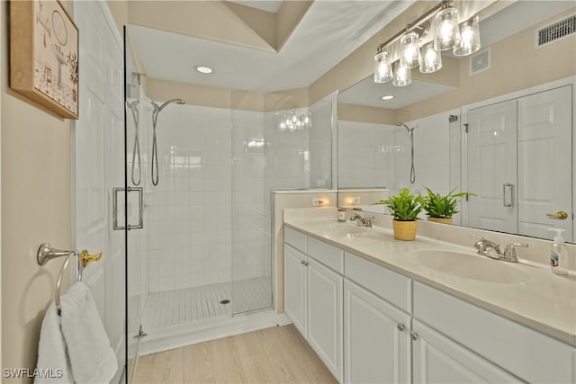 bathroom featuring hardwood / wood-style floors, vanity, and a shower with shower door