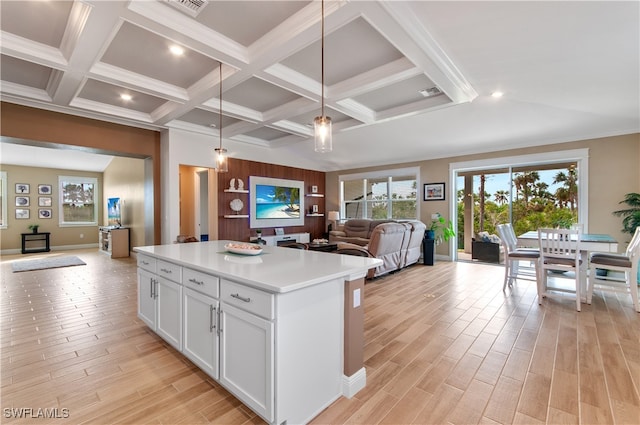 kitchen with light hardwood / wood-style floors, a kitchen island, white cabinetry, and hanging light fixtures