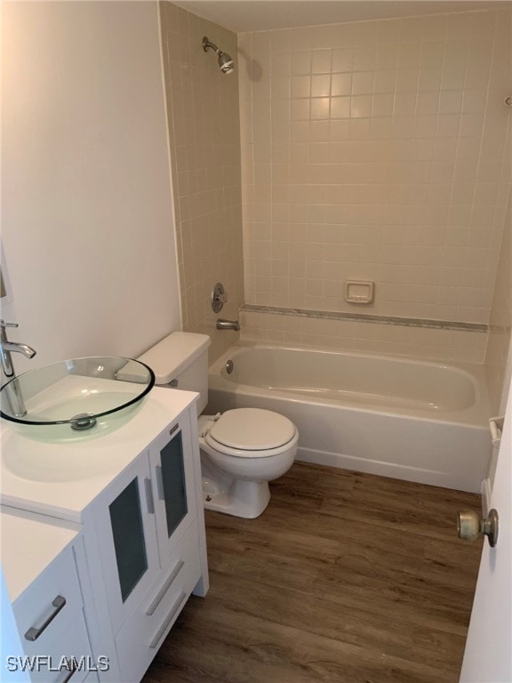 full bathroom with wood-type flooring, vanity, toilet, and tiled shower / bath