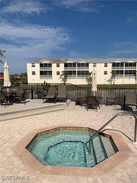 view of swimming pool with a patio area and a community hot tub