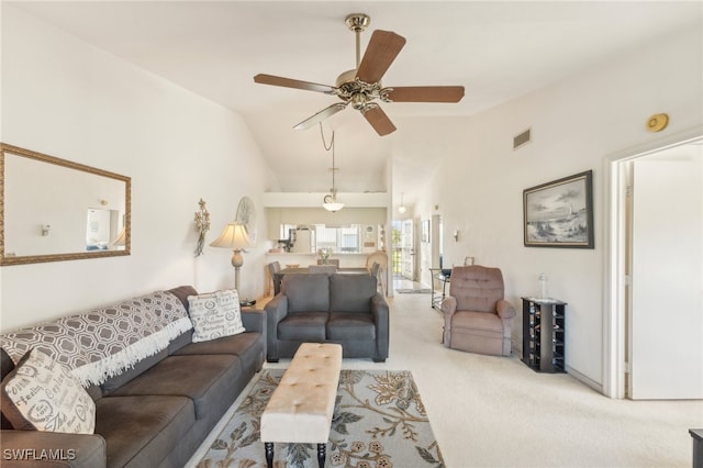 carpeted living room with ceiling fan and vaulted ceiling