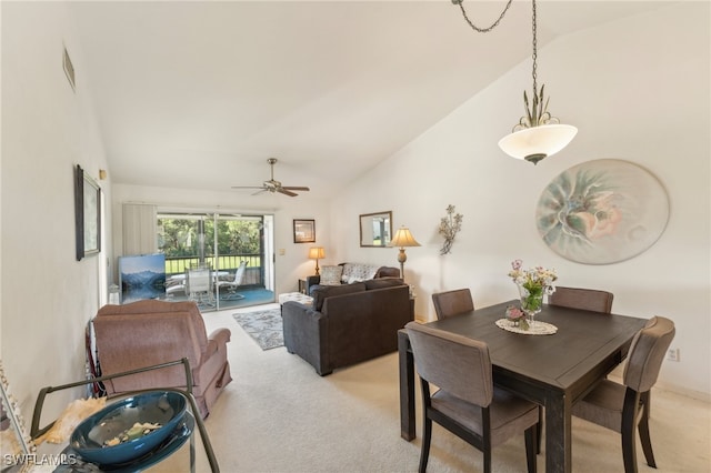 carpeted dining room with high vaulted ceiling and ceiling fan