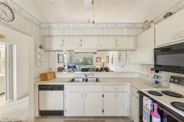 kitchen featuring lofted ceiling, white appliances, sink, light tile patterned flooring, and white cabinetry