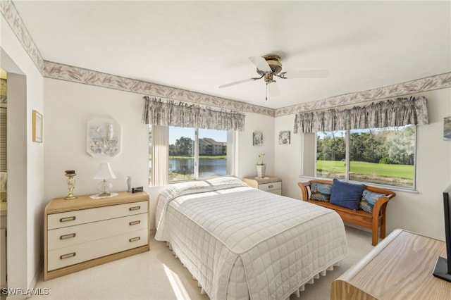 carpeted bedroom with ceiling fan and multiple windows