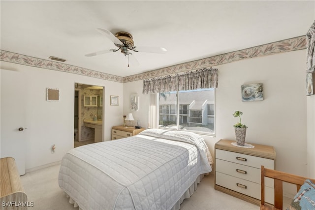 bedroom featuring ceiling fan, light carpet, and connected bathroom