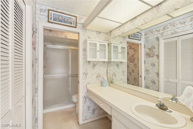 bathroom with vanity, toilet, and an enclosed shower