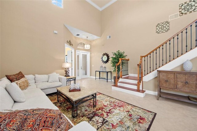 living room featuring a chandelier, light tile patterned floors, a towering ceiling, and crown molding