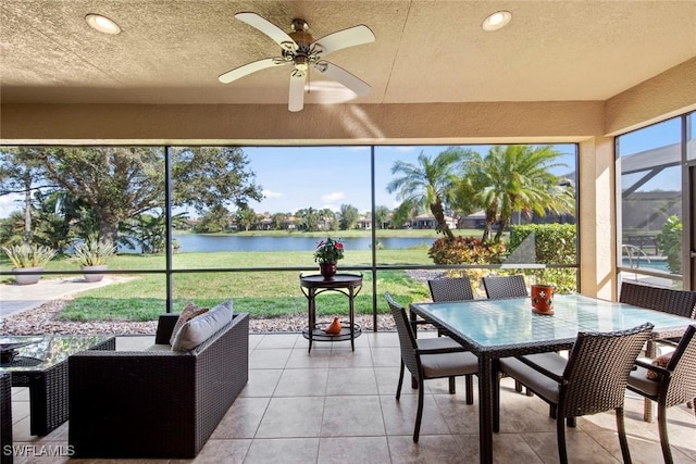 sunroom / solarium with a water view and ceiling fan