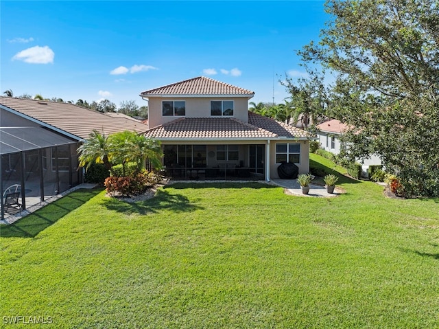 rear view of house with a yard and a lanai