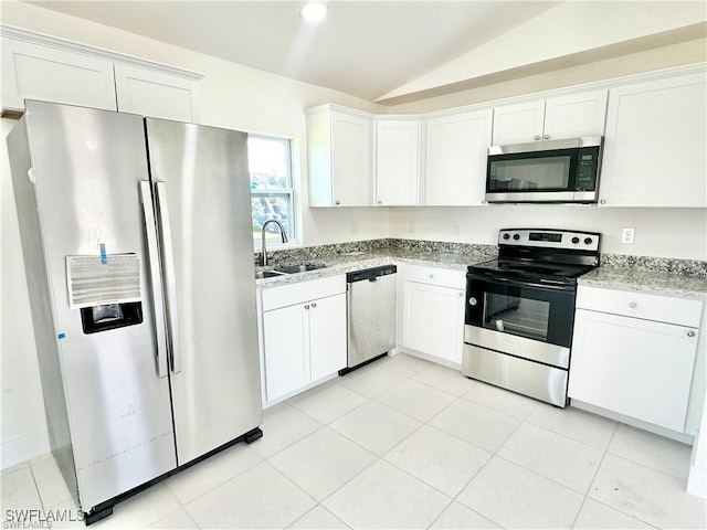 kitchen featuring stainless steel appliances, vaulted ceiling, white cabinetry, and sink