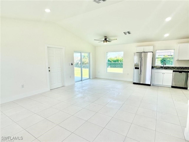 unfurnished living room with ceiling fan, sink, light tile patterned floors, and lofted ceiling