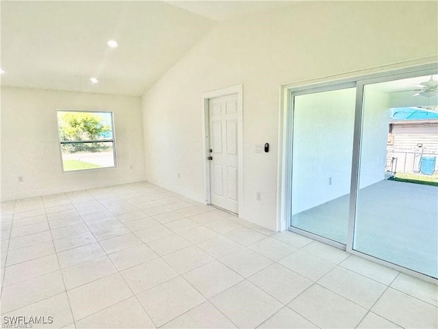 unfurnished room with lofted ceiling and light tile patterned flooring