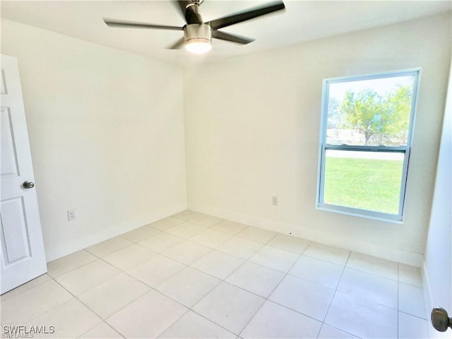 spare room with ceiling fan and light tile patterned floors