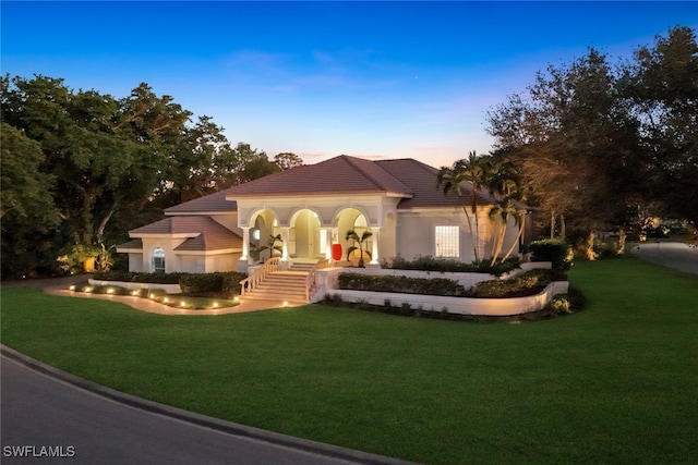 mediterranean / spanish house featuring a lawn