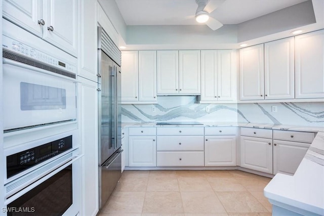 kitchen featuring decorative backsplash, white cabinetry, and light tile patterned floors