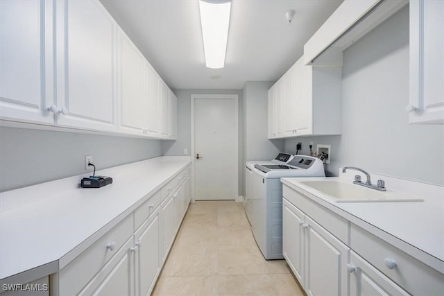 washroom with light tile patterned flooring, cabinets, independent washer and dryer, and sink