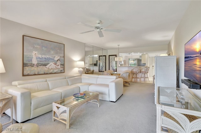 carpeted living room with ceiling fan