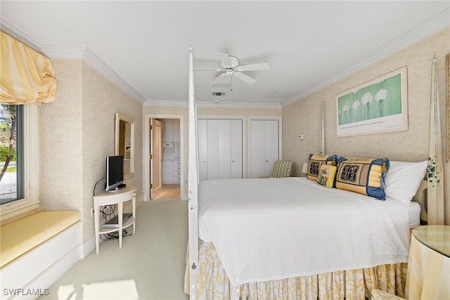 carpeted bedroom featuring ceiling fan, crown molding, and two closets