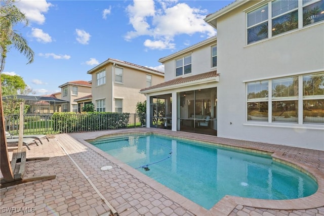 view of swimming pool with a fenced in pool, fence, a patio, and a sunroom