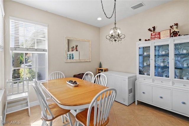 tiled dining space with a notable chandelier