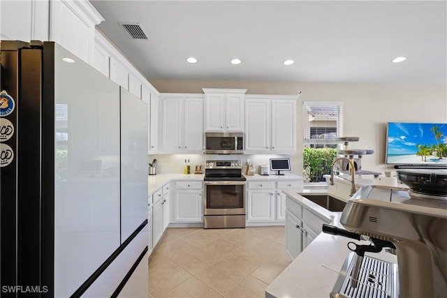 kitchen featuring light tile patterned flooring, white cabinetry, sink, and appliances with stainless steel finishes