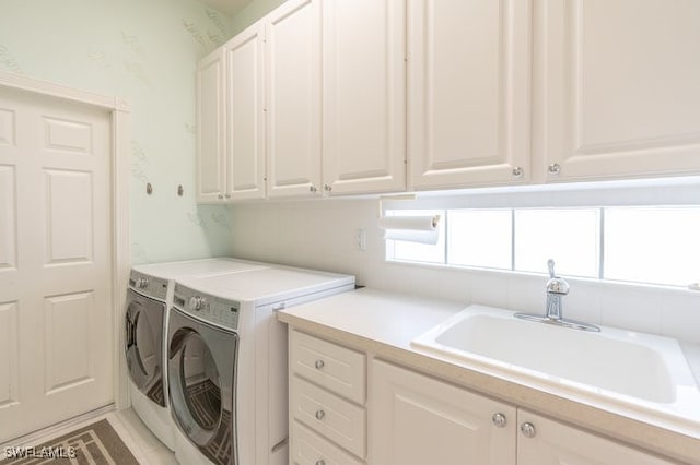 laundry area featuring plenty of natural light, cabinets, independent washer and dryer, and sink